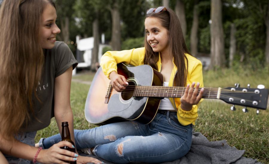 cerrar-mujer-tocando-la-guitarra-al-aire-libre