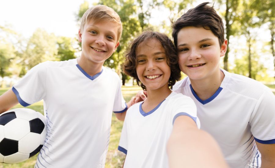 ninos-de-vista-frontal-en-ropa-deportiva-de-futbol-tomando-un-selfie